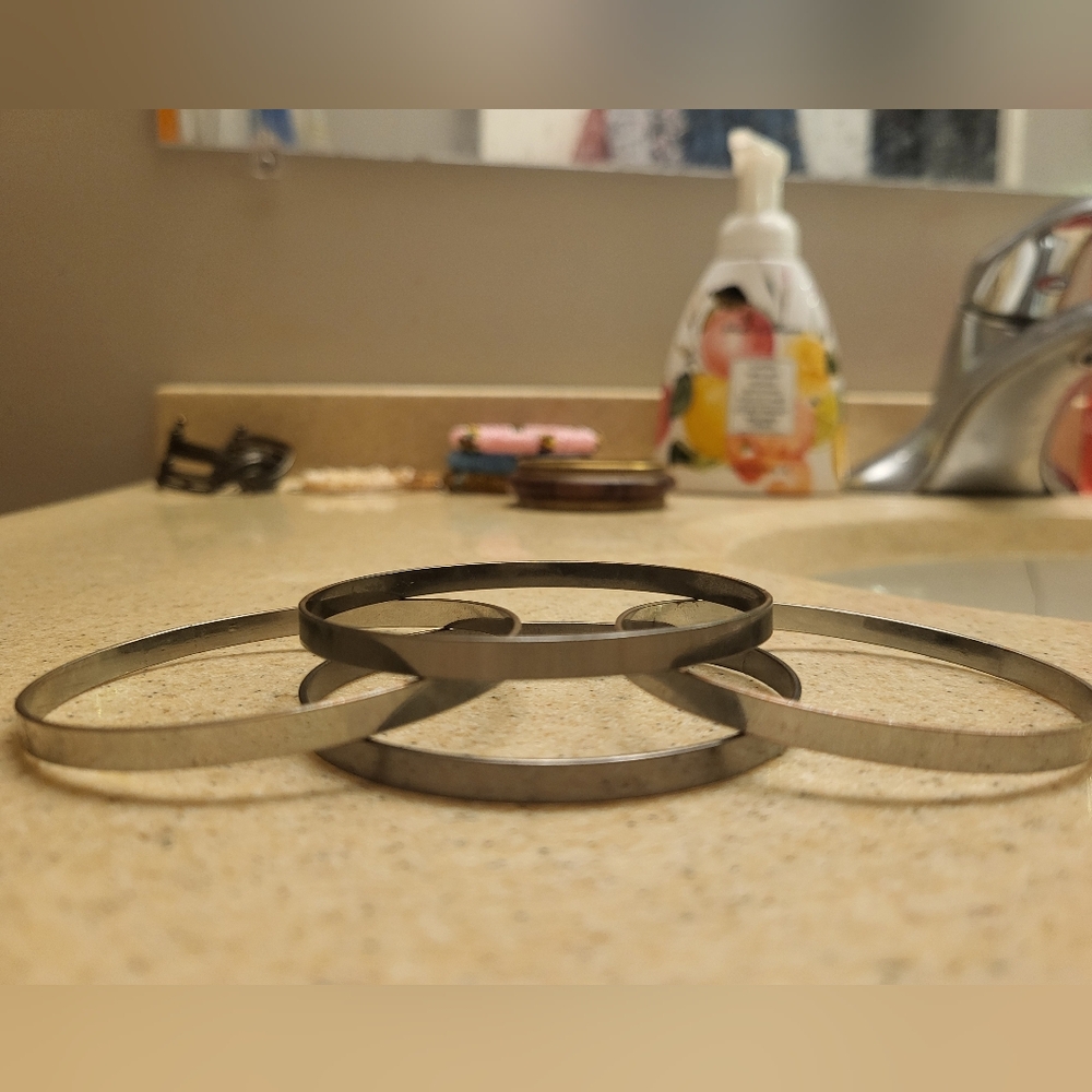 Four smooth metal bracelets